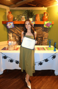 Briana Powell holding her PsyD graduation certificate