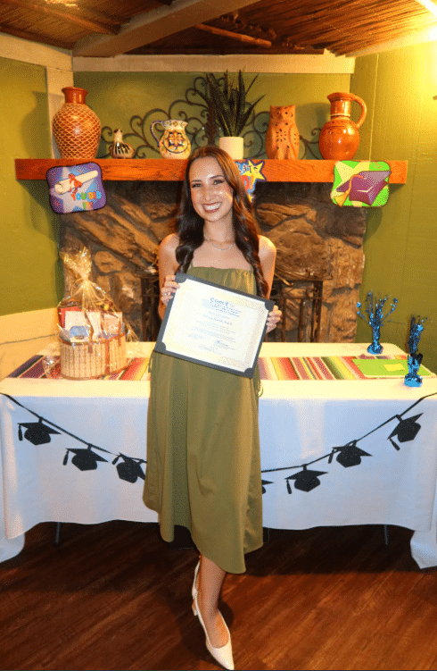 Briana Powell holding her PsyD graduation certificate